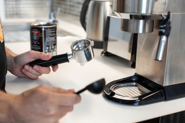 Guy prepare delicious aromatic coffee in a coffee machine. A simple way to make coffee