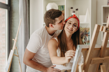 Love story of a beautiful couple in an art studio. They paint pictures, laugh, kiss each other....