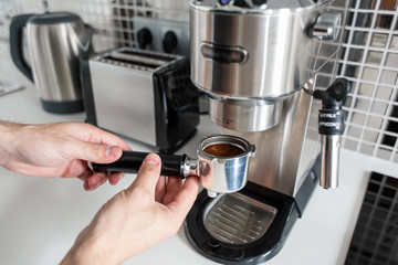 Guy prepare delicious aromatic coffee in a coffee machine. A simple way to make coffee
