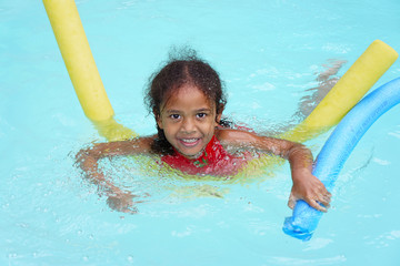 Multiracial ethnic girl child learning to swim