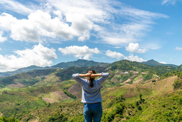 Fototapeta na wymiar Women with backpacks and hat spreading hands feelings happy and relaxing with nature mountain background. Freedom concept travel in Thailand.