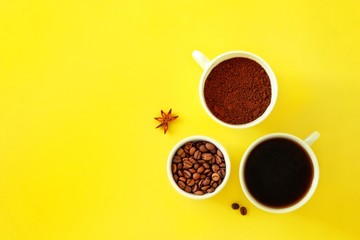 Three ceramic white cups with various coffee on a yellow background.Concept cafe, kitchen. Top view, copy space for text.