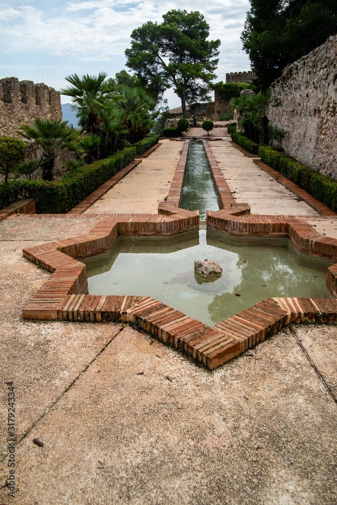 Canvas Prints water fountain onthe ground suounded by beautiful trees and rocks in xativa, spain