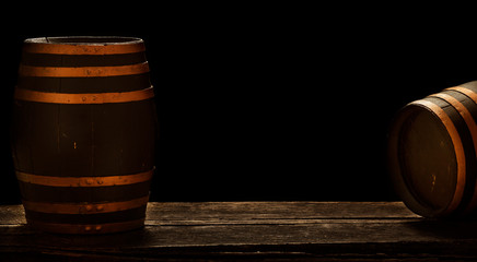 Two wooden barrels stand in a dark basement, banners with storage space or copy space