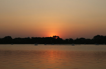 Fototapeta na wymiar Sunset orange lake water reflection landscape.