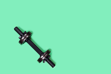 Sports picture. Dumbbell on mint green background. Flat lay, top view, copy space.