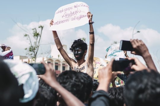 Man holding sign written in Tamil during protest, Chennai, India