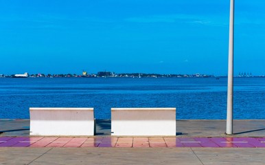 Beautiful shot of the Luanda bay with buildings in the distance under a blue sky