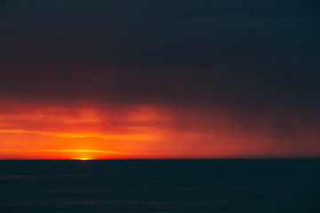 Natural Colorful Sunset Sunrise Sky Over Sea After Storm Rain. Seascape With Shining Setting Sun On Sea Horizon