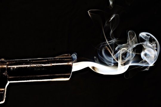 Closeup shot of a smoking gun with s black background