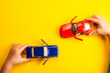 two toy cars on a yellow background