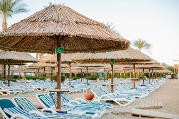 The sign for disabled on the beach near sun bed and umbrellas 