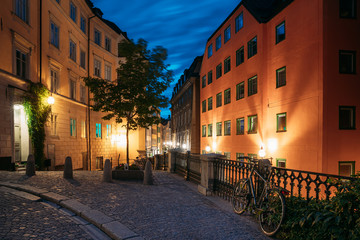Fototapeta premium Stockholm, Sweden. Night View Of Traditional Stockholm Street. Residential Area, Cozy Street In Downtown. Osterlanggatan Street In Historical District Gamla Stan. Parked Bicycle Bike In European City