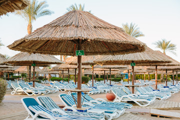 The sign for disabled on the beach near sun bed and umbrellas 