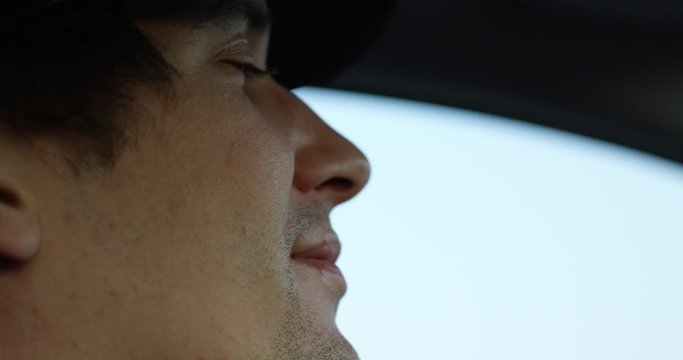 Man driving car - extreme close up on face as he closes eyes - tired driver