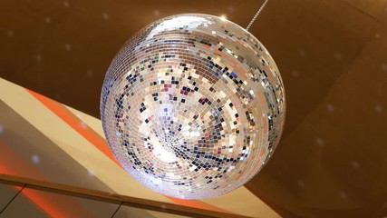 Rotating sparkling disco ball. Mirror disco ball reflecting yellow lights on golden background. Night party concept 4k - Powered by Adobe