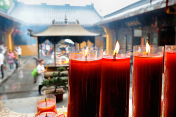 Burning red candles in Buddhist temple in Asia.