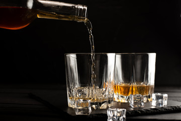 glass of whiskey and ice on wooden table
