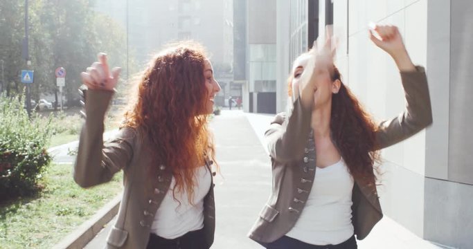 Twin sisters going out together. Beautiful red hair girls spending time outdoor