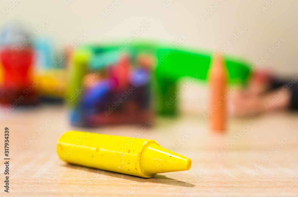 Sticker Closeup shot of a yellow crayon on a wooden surface