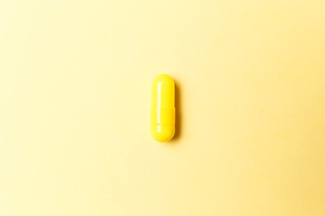 Pharmaceutical medicine pills, tablets and capsules on yellow background. Top view. Flat lay. Copy space. Medicine concepts. Minimalistic abstract concept. Antibiotics, painkillers, vitamins
