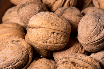 Walnut kernels in basket and whole walnuts on rustic old wood