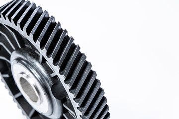 Black polymer gear camshaft with metal base. New spare part for an internal combustion engine on a gray background