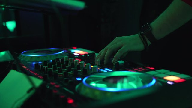 DJ hands at the sound console and laptop at a party
