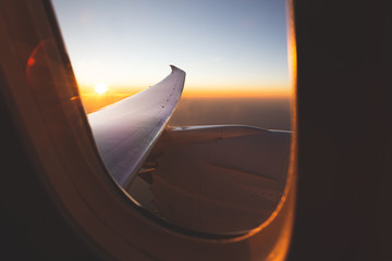 Aerial views from the window of the plane at sunset. Travel by plane concept.