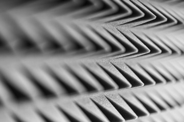 Grey acoustic foam pyramid repeating background for music Studio. Black and white. Close-up view...