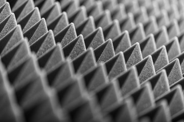 Grey acoustic foam pyramid repeating background for music Studio. Black and white. Close-up view...