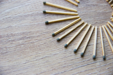 circle lined with matches are on a beige wooden