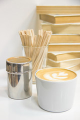 coffee with heart pattern, sticks, сinnamon, books