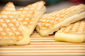 cheesy club sandwiches on a wooden chopping board