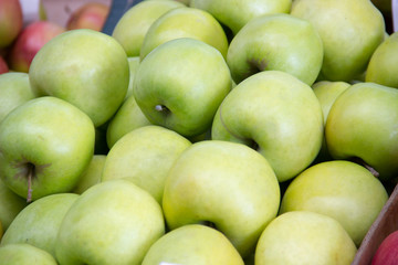 Green apples for sale in a box on the counter