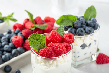 Cottage cheese with cream, raspberry and blueberry .