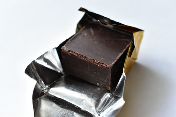 A piece of chocolate in a gold wrapper.