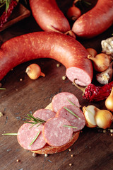 Sandwich with salami on a old wooden table.