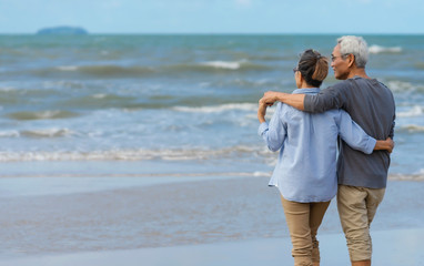 Fototapeta na wymiar Asian senior couple elder retire resting relax walking at sunrise beach honeymoon.Happy family together people lifestyle
