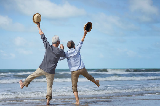 Asian senior couple elder retire resting relax walking at sunrise beach honeymoon.Happy family together people lifestyle