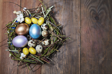 Easter eggs in nest on rustic wooden table