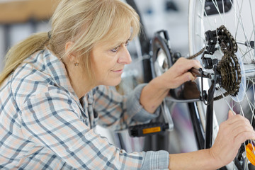 mature woman fixing wheels in workshop