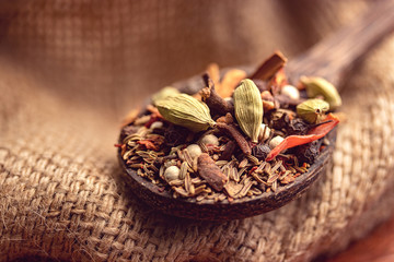 mix spices and herbs in a wooden spoon on dark background, Indian spices food and cuisine ingredients