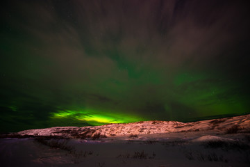 hills, clear starry sky and colorful Northern lights, an incredible natural phenomenon