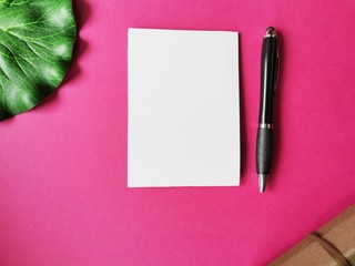 notebook, pen, on pink background.  top view copy space