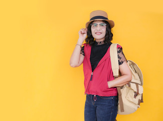 Senior woman 60 years old traveler in studio isolated on yellow wall wearing eyeglasses and backpacking.
