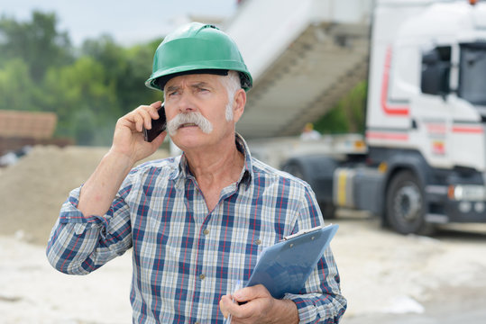 Portrait Of Senior Factory Business Owner On The Phone