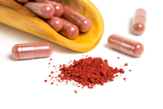Red yeast rice or angkak or kojic rice powder and supplemet capsule on white isolated background