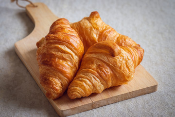 Fresh croissants on wooden board