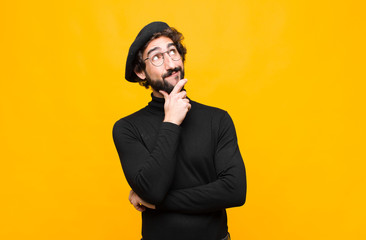 young french artist man feeling thoughtful, wondering or imagining ideas, daydreaming and looking...
